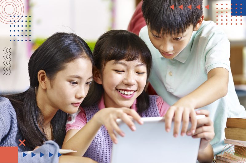 Group of school students discussing the PSLE scoring system using a tablet.