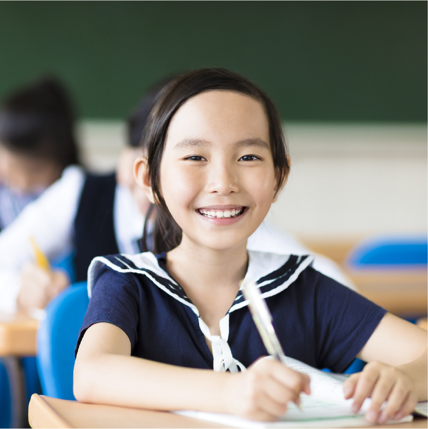 A happy schoolgirl in the classroom.
