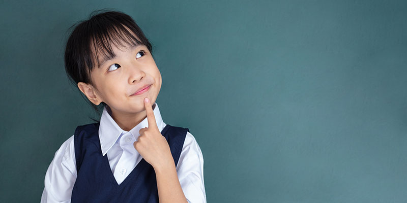 With her fingers on her chin, a primary school girl student thinks about the PSLE English exam.